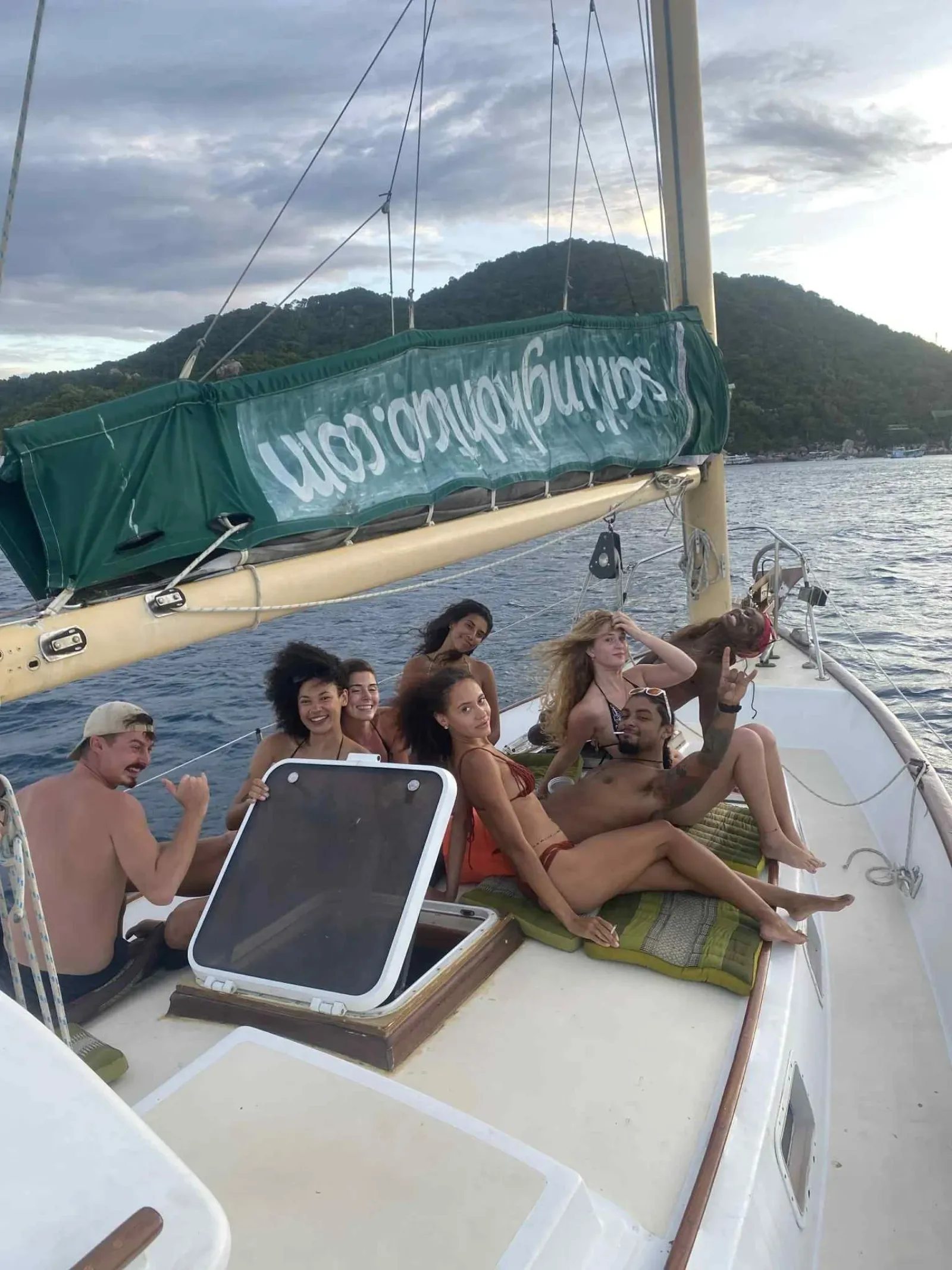 Guests relaxing on deck during a sailing cruise at golden hour